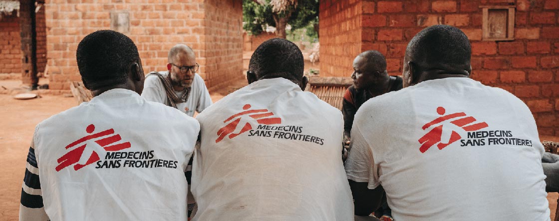 5 membres du personnel de MSF en train de discuter, vêtus d'un T-shirt blanc avec logo MSF