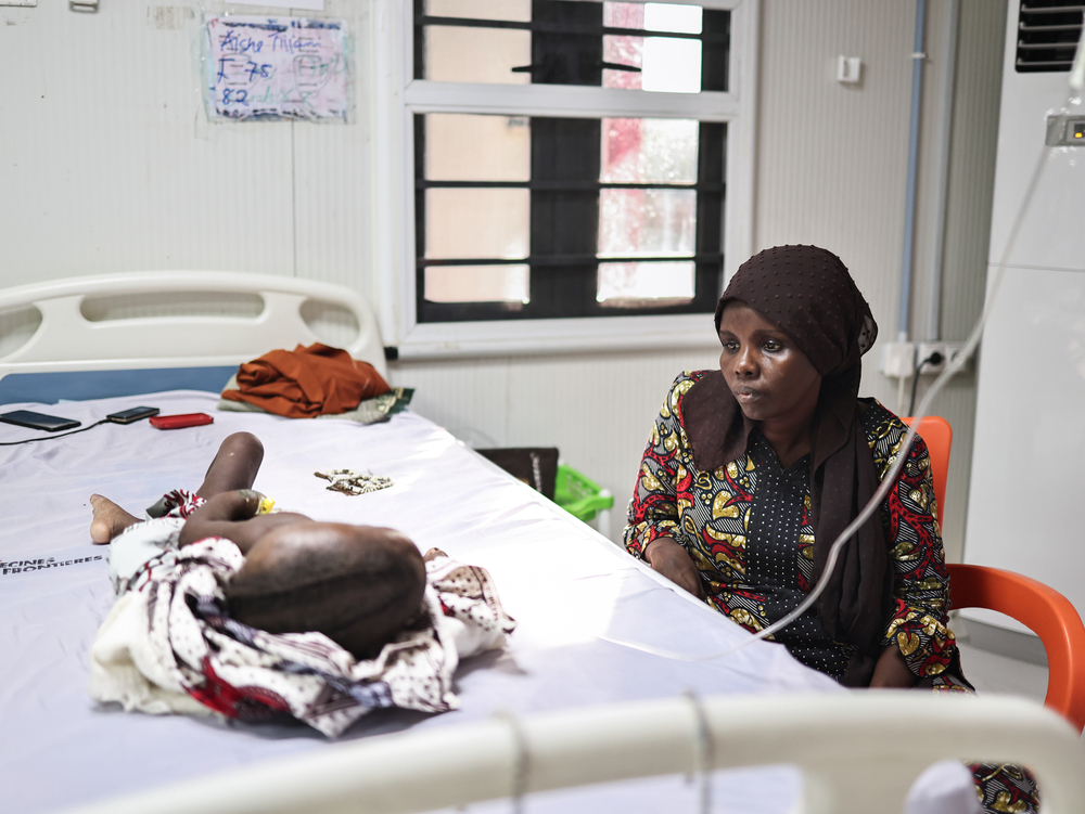 Fatima Ibrahim regarde sa fille Aisha Tijjani, âgée de 23 mois, hospitalisée et soignée pour malnutrition au centre MSF Nilefa Kiji, à Maiduguri, dans l'État de Borno, au nord-est du Nigéria. Fatima y a déjà passé environ trois semaines pour s'occuper d'Aisha.