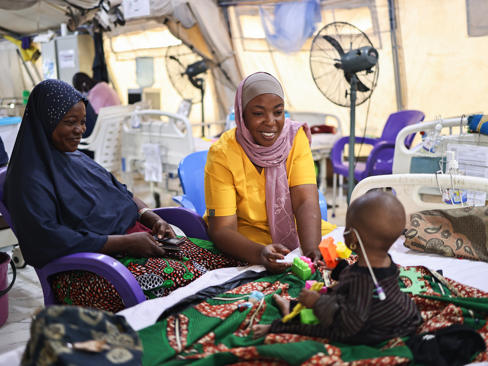 Maryam Alimu, conseillère et formatrice pour MSF, anime une séance de thérapie par le jeu avec Aisha Abdulkareem, la fille de sept mois de Latifat Abdulkareem, hospitalisée et soignée pour malnutrition au centre MSF Nilefa Kiji, à Maiduguri, dans l'État de Borno, au nord-est du Nigeria. Nigéria, novembre 2025 ©Abba Adamu Musa/MSF