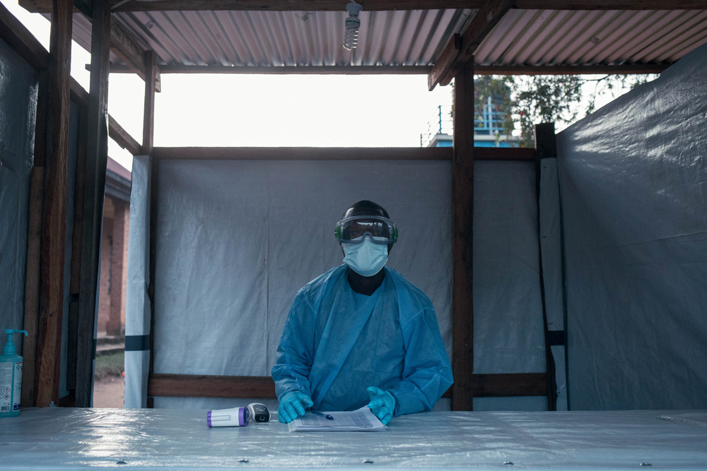 Un membre du personnel hospitalier effectue un contrôle de température et veille à ce que toute personne entrant à l'hôpital général de référence de Fataki se lave les mains, conformément aux mesures de prévention et de contrôle de l'infection par Ebola.
