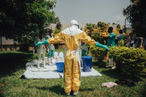 Une fois toute la maison décontaminée, l'étape de déshabillage doit être menée scrupuleusement. Le risque de contamination est élevé car il y a très probablement la présence du virus sur la combinaison. Bunia, Ituri, RDC ©Jilien Dewarichet/MSF