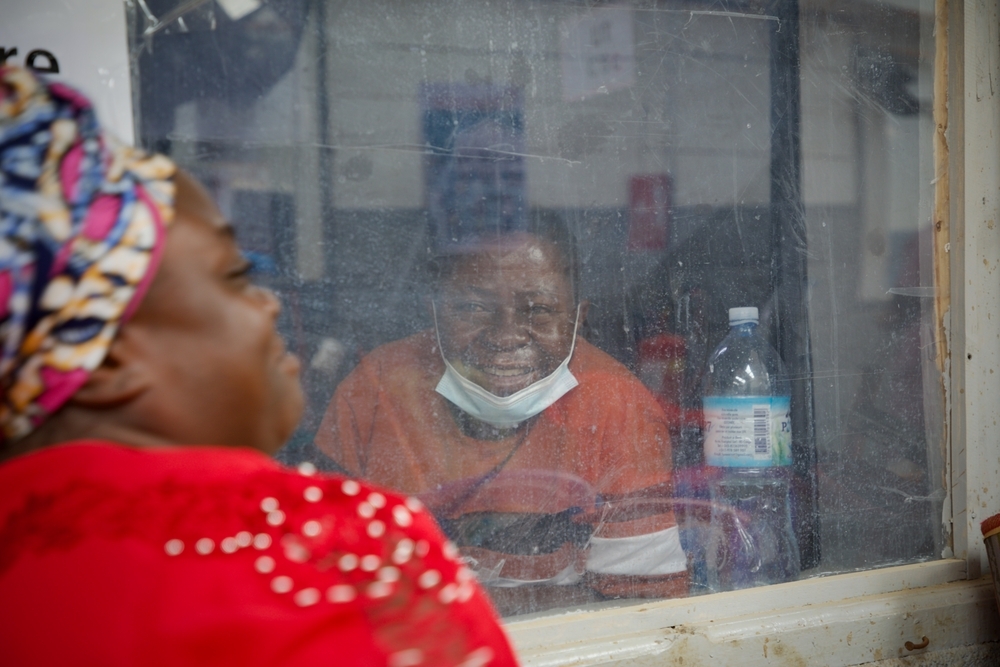 Victoire, atteint du virus Ebola, passe ses journées au centre de traitement Ebola (CTE) de Kitatumba, à Butembo, en attendant de pouvoir sortir, son état de santé s’améliorant. Il pense avoir contracté le virus alors qu’il travaillait comme infirmier dans un autre hôpital, en s’occupant d’un patient qui a par la suite été déclaré positif au virus Ebola. Son épouse, Kasoki, vient chaque jour — de 6 h 30 à 18 h 30 — pour le soutenir et veiller sur lui. RDC, Butembo, Octobre 2026 ©Elio Parfait/MSF