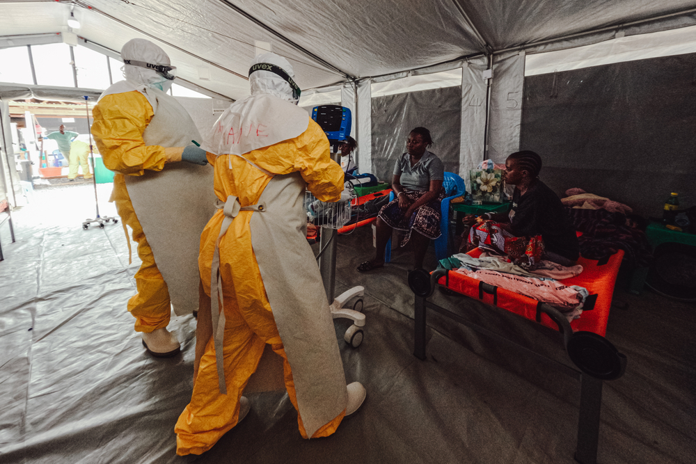 Deux infirmières viennent voir Pierrette, patiente dont les résultats ont confirmé son infection au virus depuis plusieurs jours. Son état s'est nettement améliorée depuis sont arrivée au centre. RDC, Juillet 2026 ©Julien Dewarichet/MSF