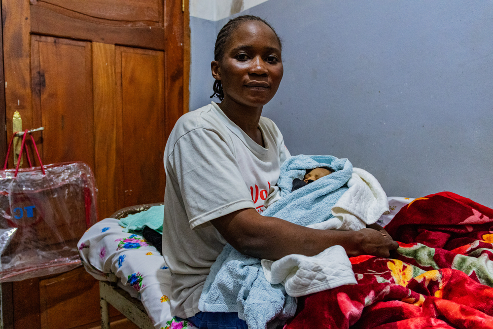 Marlique est une survivante de la maladie à virus Ebola, âgée de 21 ans. Elle est mère de deux enfants et est originaire de Butembo. Elle a été admise dans un centre de traitement Ebola à la mi-mai 2026 avant d'être testée positive puis de sortir guérie un mois après. En tant que survivante, elle est immunisée. Butembo, RDC, août 2026 ©Lucie Ringué/MSF