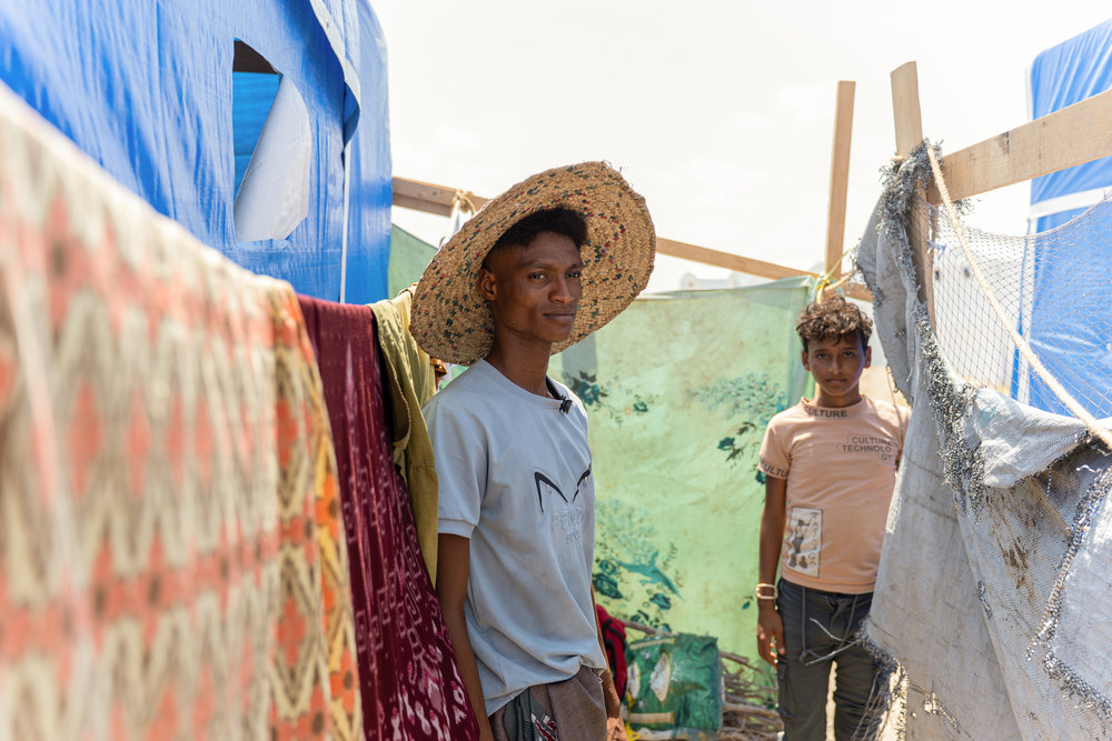 « Je suis venu avec ma mère, ma tante, ma grand-mère et mes frères. C’est toute la famille. Nous avons fui par miracle, car les routes étaient fermées », explique Maher, debout aux côtés de son voisin qui vit dans la tente juste à côté de la sienne. Yemen, Aden, octobre 2026©Alexandre Marcou/MSF